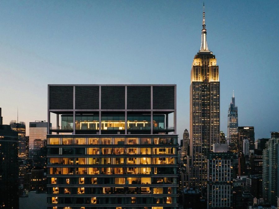 A city rooftop at blue hour beside a lit skyline