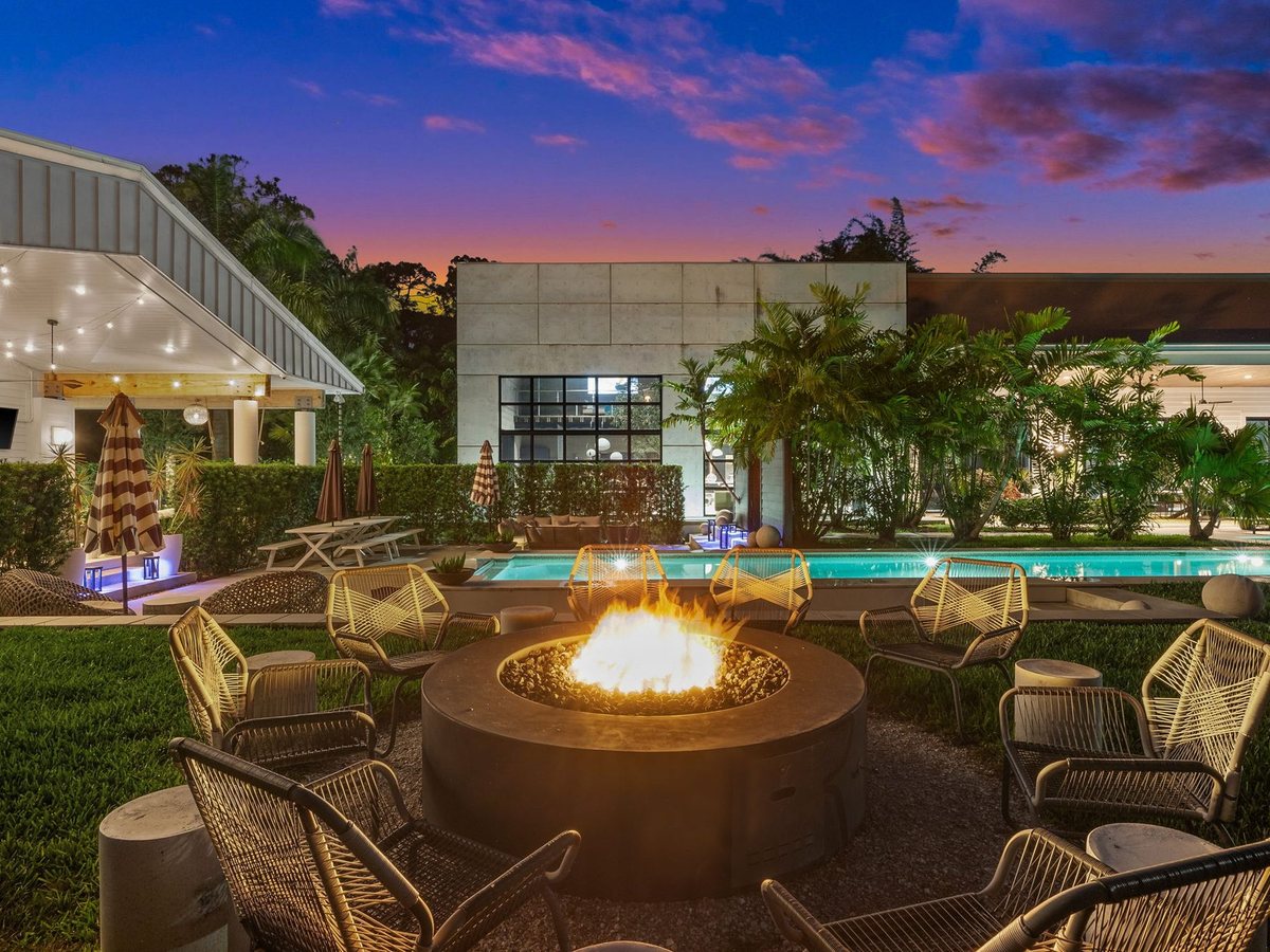 An estate pool and fire pit at dusk