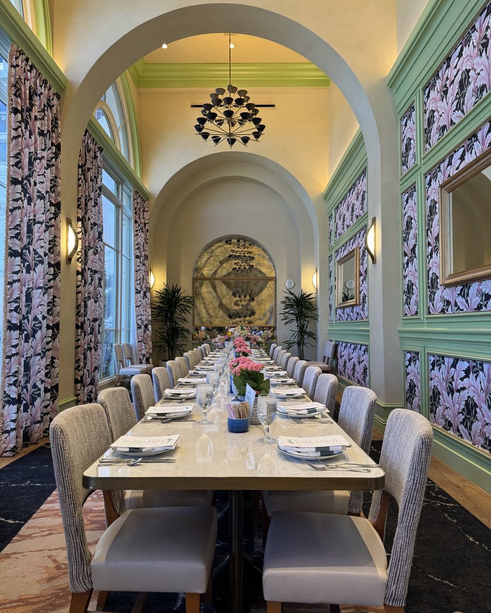 A long table set beneath arches, flowers down its center